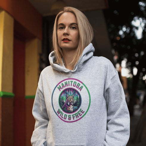 Step into the wild with our Manitoba – Wild & Free hoodie, featuring a striking graphic of a lynx under the glow of the northern lights.